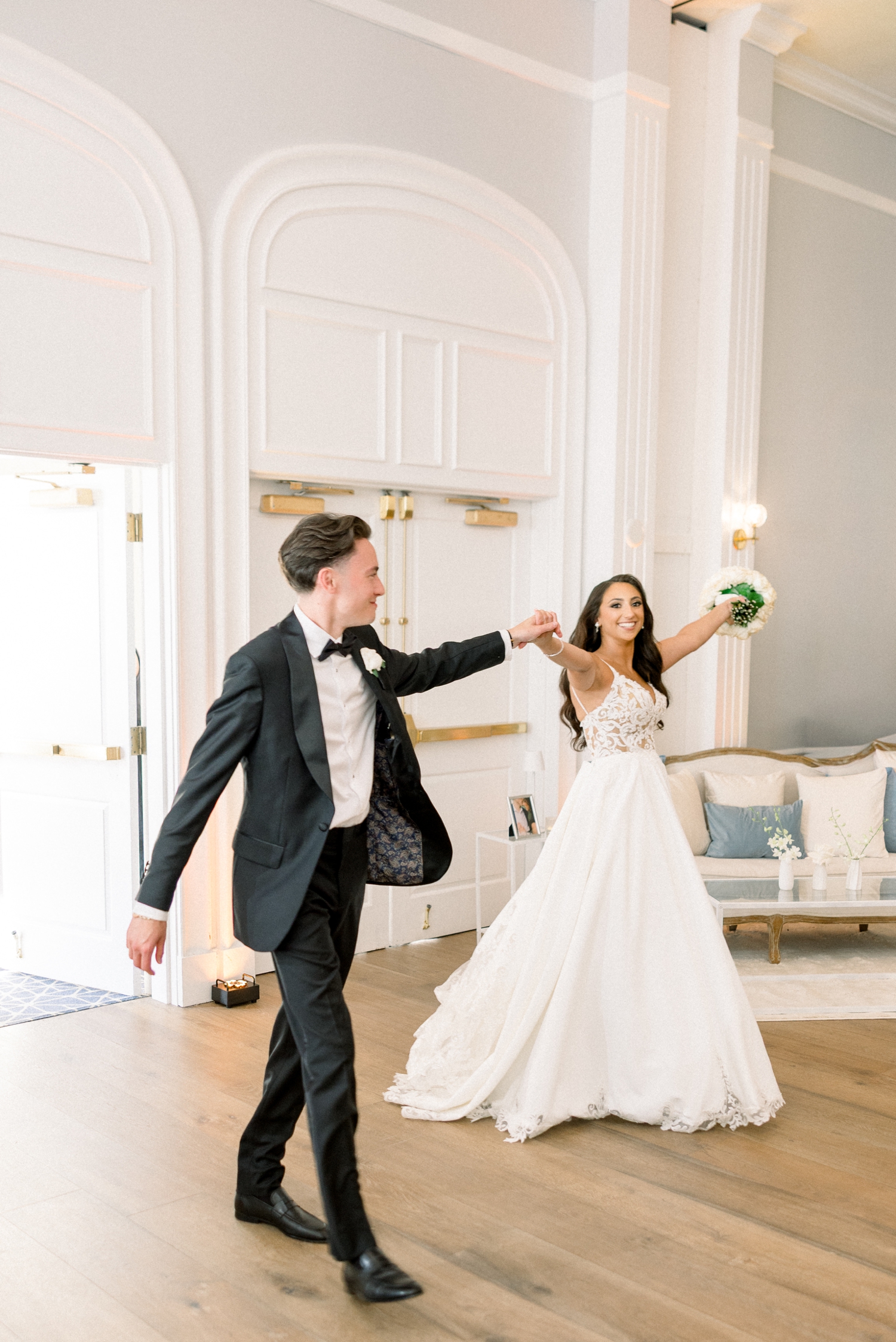 The bride and groom enter their Newport reception together in evening light.