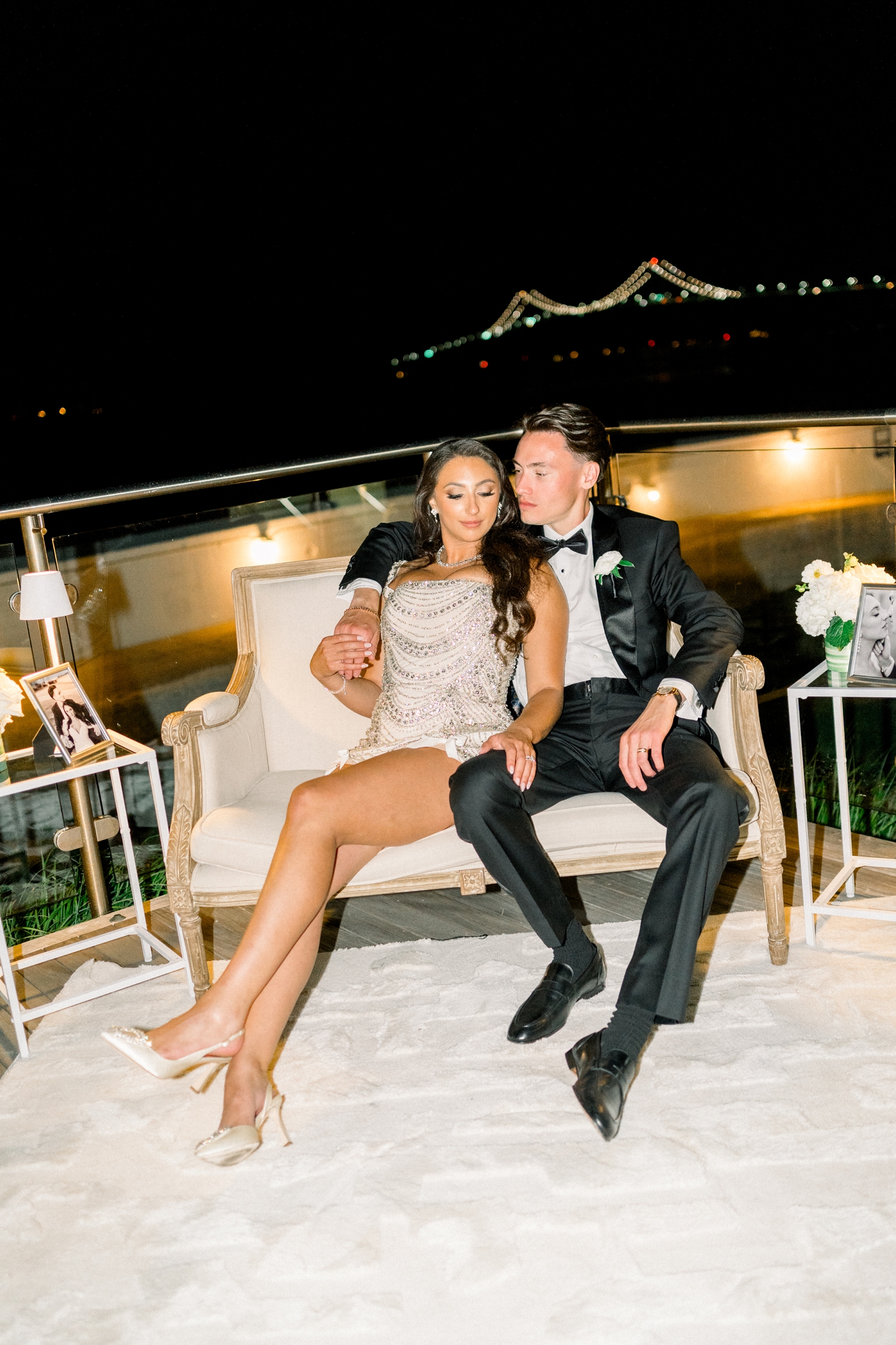 The bride dances in a beaded reception dress during her coastal black tie wedding.